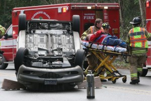 A driver involved in a two-car crash on Highway 305 in Winslow Tuesday is taken away on a gurney by emergency responders.