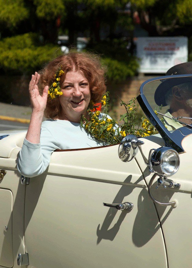 The 2014 Bainbridge Island Scotch Broom Festival Queen Mickey Molnaire waves from the head of the surprise parade as it rolled down Winslow Way.
