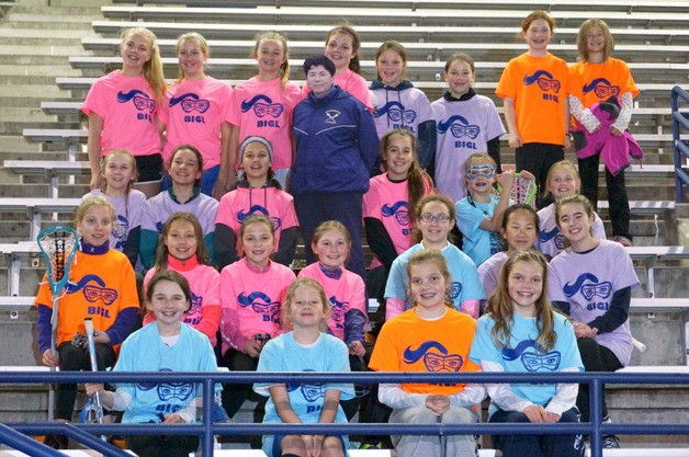 Bainbridge girls who came out to have fun at the first LAX Under the Lights gather for a photo around the cardboard cutout of BHS Coach Tami Tommila.