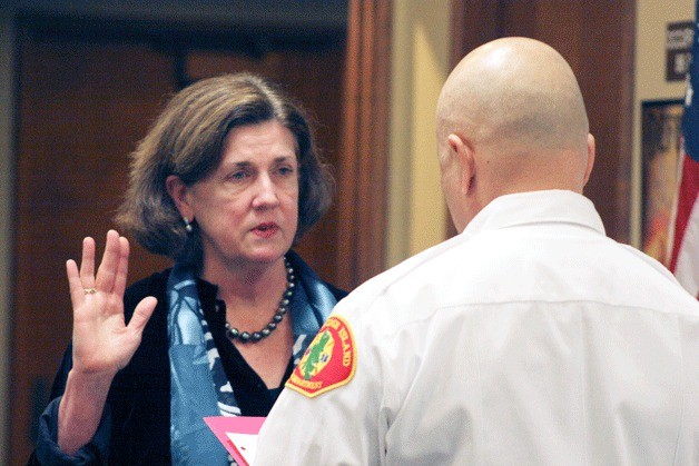 Eileen McSherry takes the oath of office as a Bainbridge Island fire commissioner at this week's board meeting.
