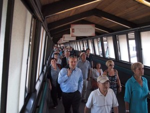 Islanders and visitors exit underneath historical banners at the Bainbridge Island Ferry Terminal following a ride across the Puget Sound.