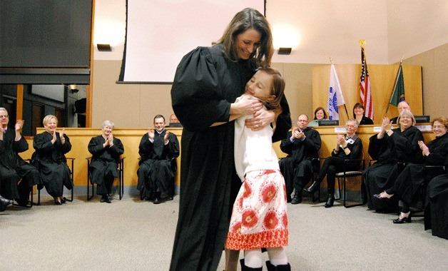New Bainbridge Island Municipal Court Judge Sara L. McCulloch gets a hug from her daughter after taking the oath of office at Wednesday’s Bainbridge Island City Council meeting.