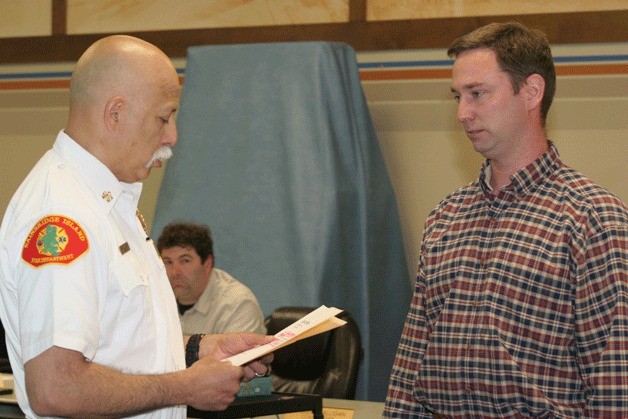 Bainbridge Island Fire Chief Hank Teran begins to read the oath of office to incoming Fire Commissioner Dan Morrow. Morrow will serve in Position 3 on the board.