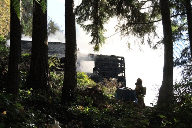 A firefighter looks up at the charred remains of a North Bainbridge home that was consumed by a Sunday morning fire on Nov. 16.