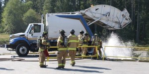 Bainbridge Island firefighters soak a pile of trash