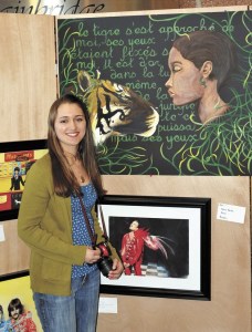Isabelle Ranson stands next to her large acrylic painting titled “Jungle