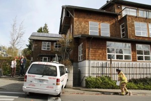 A firefighter with the Bainbridge Island Fire Department spreads absorbent material along Winslow Way after a taxi van hit the outside of the San Juan Building in Winslow Monday.
