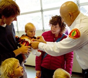 A Bainbridge youngster gets a sticker badge from Bainbridge Fire Chief Hank Teran at the volunteers' pancake breakfast.