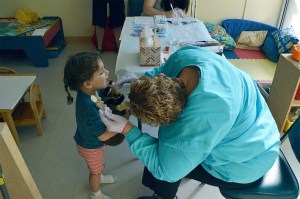 A preschooler at Peacock Family Center bravely bares her teeth for Kathy Hamlett