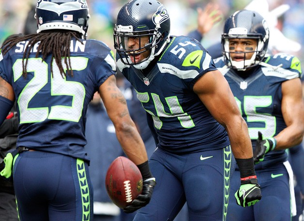 Bobby Wagner (54) and Richard Sherman (25) celebrate Sherman's first interception of the game in the first quarter of the NFC Championship.