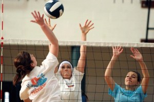 Kyra Easley elevates to hit the ball past fellow Spartans Emilia Dronkert and Adrienne Fountain at volleyball practice this week.