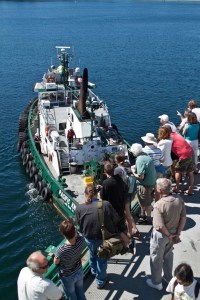 Passengers on the ferry MV Tacoma watch as a tugboat helps bring the broken-down vessel to Bainbridge Island.