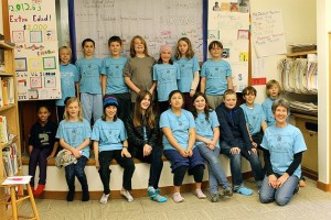 The Island School fifth-graders pose together with a faux check in the background that they presented to a Bainbridge Ometepe Sister Islands Association member. The funds raised by a calendar they created and sold will support various projects in Ometepe.