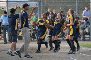 Coach Brian D’Amato and manager Eric Wikstrom rush to congratulate pitcher Malia Peato