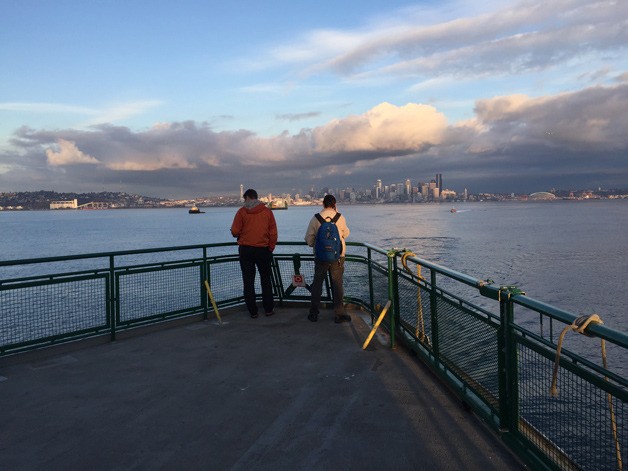 Passengers aboard the ferry M/V Puyallup look over the side of the ship as the ferry is stopped between Seattle and Bainbridge Island following a report of a man overboard Wednesday evening.