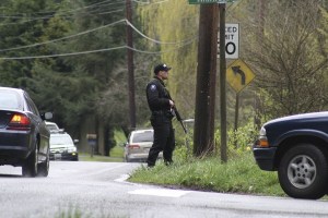 A Bainbridge Island Police Department officer carries an AR-15 while holding containment for a manhunt Thursday at the Miller Road-Battle Point Drive intersection. The BIPD
