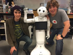 The new Spartronics co-captain Alex Larson-Freeman and past co-captain  Kolin Hawkins gather for a photo with the humanoid robot Pepper.