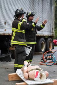 Course instructors review the  performance of participating  firefighters after an extrication drill.