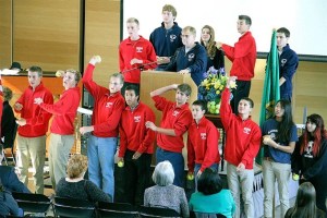 Members of the Kingston and Bainbridge tennis teams throw tennis balls into the crowd at the end of the memorial for Mike Anderson
