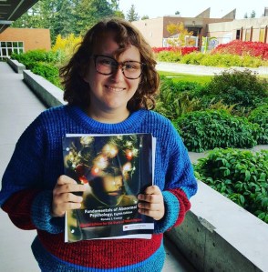 Julia Fradkin shows off her copy of  “The Fundamentals of Abnormal Psychology.”