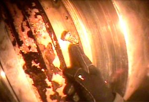 A diver conducting an inspection of the propeller shaft of the ferry M/V Puyallup points to a bent bolt inside the ferry's propeller shaft seal.