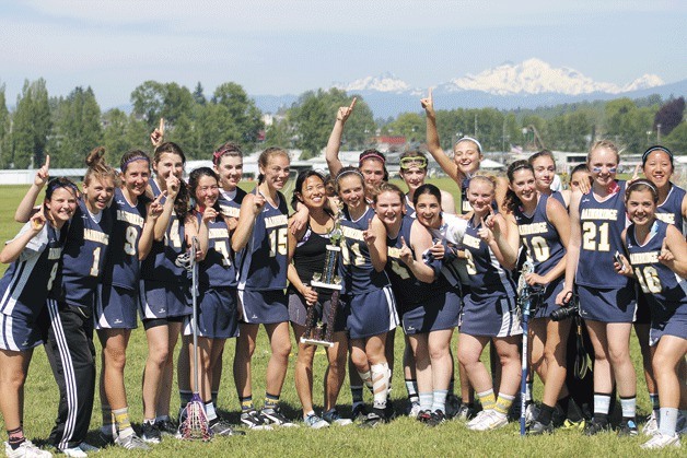 The Bainbridge High girls JV lacrosse team gathers around their trophy after winning the state title against Mercer Island.