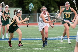 Junior midfielder Kiera Havill picks up one of the many ground balls in the win against Overlake Tuesday night at Bainbridge High School. The Spartans remain undefeated