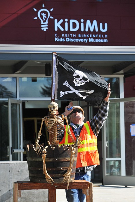 A pirate treehouse was delivered to KiDiMu’s new location at the corner of State Route 305 and Winslow Way Tuesday. The Island Gateway Superintendent Alex Olson unfurls the flag that will fly atop the treehouse.