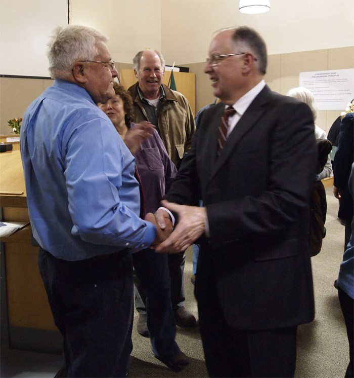 Outgoing Council Member Bill Knobloch shakes hands with Council Member-elect Steve Bonkowski at Wednesday night's swearing in ceremony.