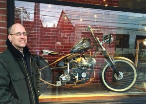 Bainbridge-based metal artist Jeremy Loerch stands with his latest custom built motorcycle