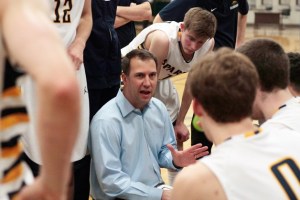 Spartan Head Coach Scott Orness talks with the varsity basketball team during a late-game timeout in Tuesday's game against Nathan Hale.