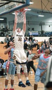 Bainbridge senior Ben Beatie hangs on the rim Tuesday during the Spartan home game against Chief Sealth. Beatie scored 16 points.