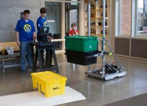 Spartronics Team Members Will Hobbs and Timo Lahtinen show a younger student how to work GAEA