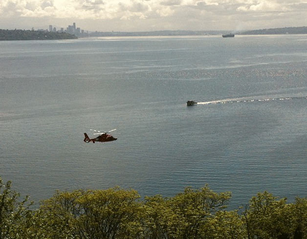 A Coast Guard helicopter and 45-foot response boat search the waters off Bainbridge Island after a swamped canoe was found Friday morning.