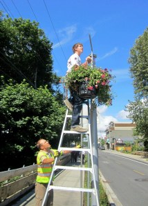 Dylan Lehotsky hangs a basket on Winslow Way.