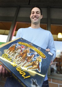 David Rohrbacher proudly displays one of his board games.