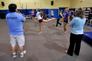 Coaches Bryan Garoutte (left) and Cindy Guy oversee 34 gymnasts on this year’s team.