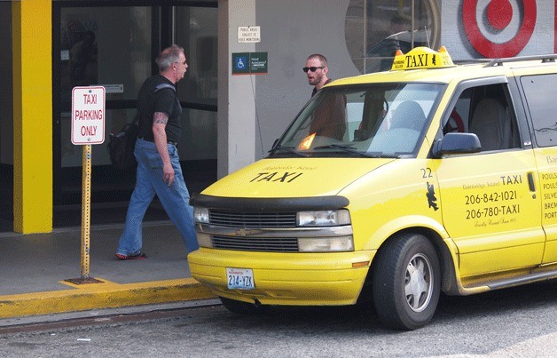 Taxis wait at the front of the ferry terminal entrance for commuters. The drive-up in front of the terminal is reserved for cabs and shuttles.
