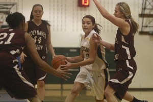 Davi Gonzales drives to the bucket as she is guarded by Erika Johnson (left) and Alexis Reichelt.