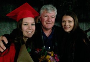 Mike Anderson poses for a picture at his daughter Hanna's high school graduation in June 2014 with his daughters Hanna and Kendra.