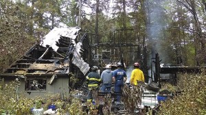 Fire department inspectors peruse the remains of a house on Peterson Hill Road Wednesday