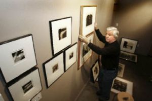 Artist Gary Groves hangs pieces for his current retrospective. The densely packed series of drawings