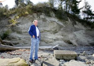 Neighboring property owner Albert Greiner stands where the slope used to be when they moved to their beachfront home