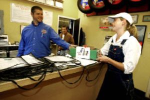 Farm Courier owner Carlee Ashen delivers a flat of strawberries from Karen Selvar’s farm to Rolling Bay Auto’s Mike Fox.