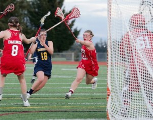 Bainbridge High’s Sallie Marx drives through Snohomish defenders during a 2013 girls high school lacrosse game. Marx has signed a Letter of Intent to play lacrosse at Pomona-Pitzer Colleges in Claremont