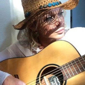 Krista Murphy helps brighten up an open house by sharing a song on her acoustic guitar.