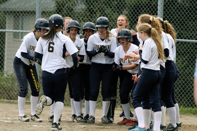 Jubilant Spartans gather at home base to welcome the sophomore slugger.