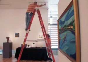 BIMA staff members place items for the upcoming anniversary auction fundraiser earlier this week. A free auction item preview will be held from 1 to 6 p.m. Friday