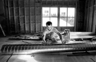 Economy Air Temp’s Harley Davison works on installing heat distribution ducts in the new addition of Bainbridge Athletic Club at Meadowmeer.