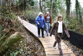 Julie Marler (front) strides the new boardwalk at the Hall Property with Lee Cross and Perry Barrett Friday afternoon. The walk provides access to the beach between Wing Point and Hawley Way.